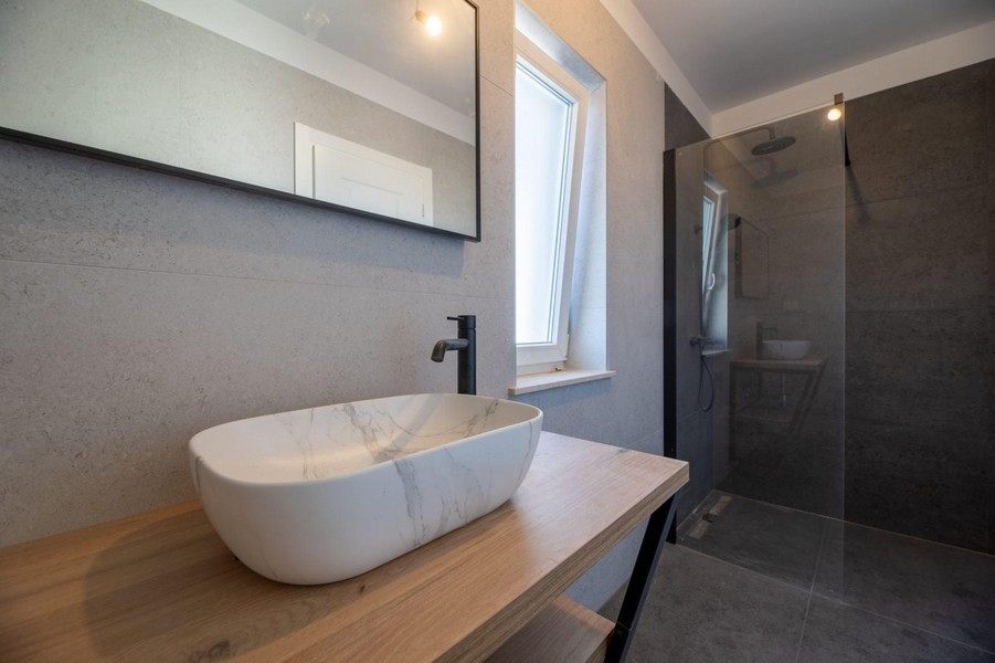 Salle de bains et lavabo moderne aspect pierre.