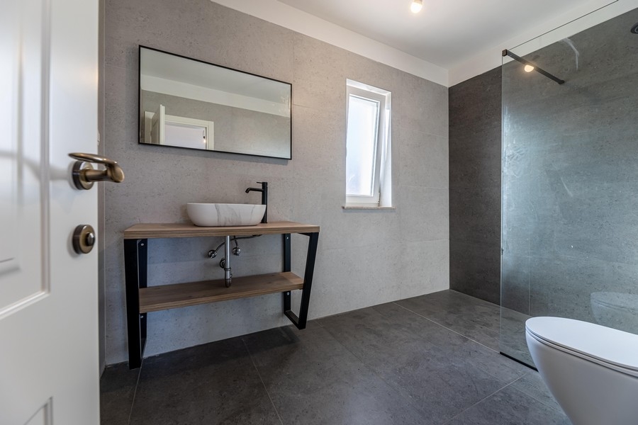Salle de bains moderne avec douche à l'italienne et carrelage foncé de la maison H3481, en vente sur l'île de Krk.
