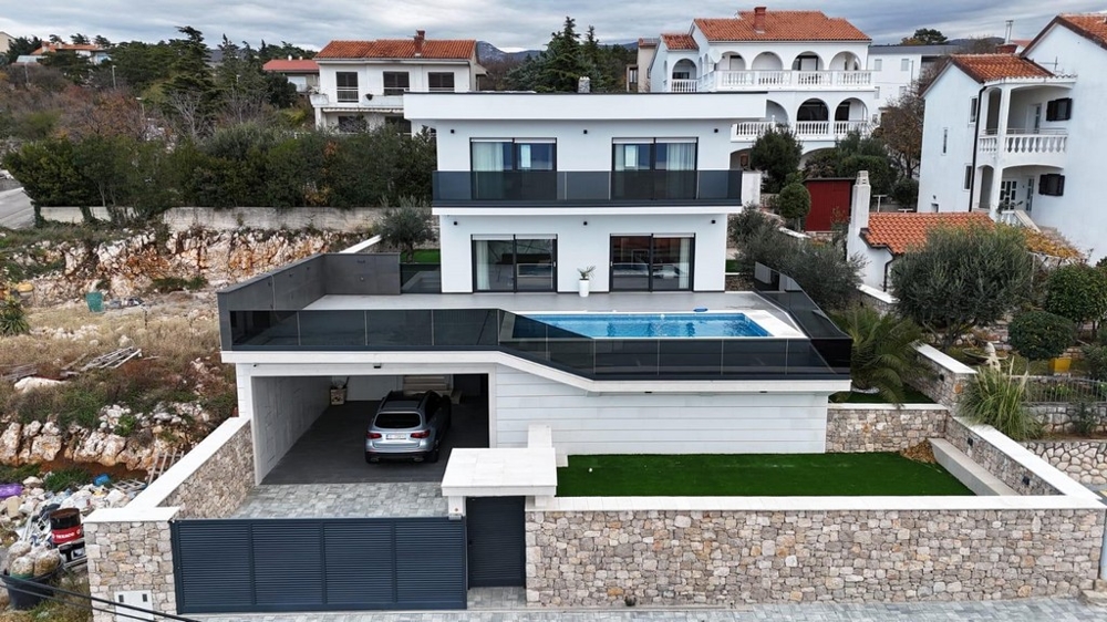Vue aérienne de la villa avec piscine sur le toit et carport en dessous