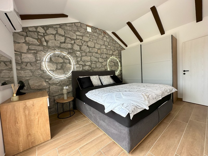 Chambre avec mur en pierre et accents modernes