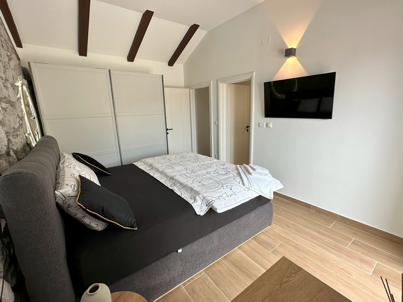 Chambre avec télévision et plafond en bois