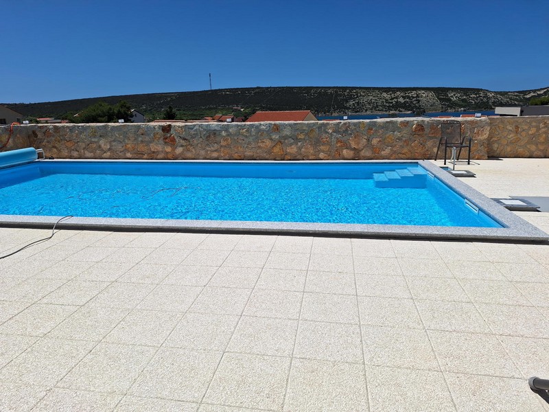 Piscine et mur en pierre méditerranéen sur le solarium.