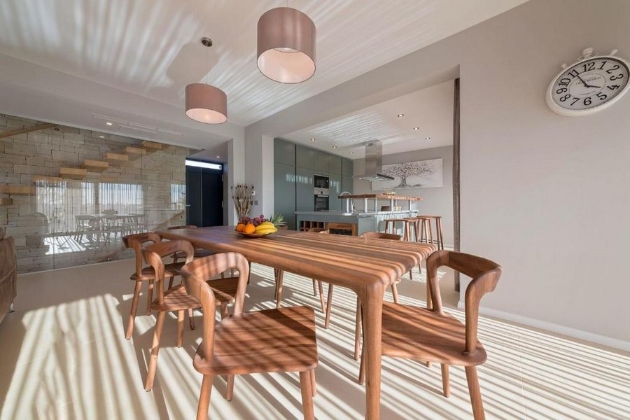 Coin repas avec table en bois et accès direct à la cuisine