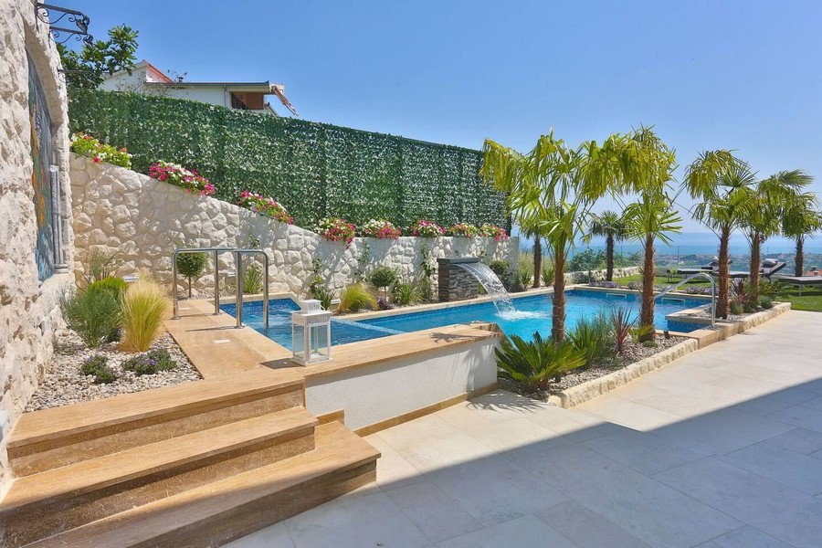 Piscine moderne avec cascade et palmiers