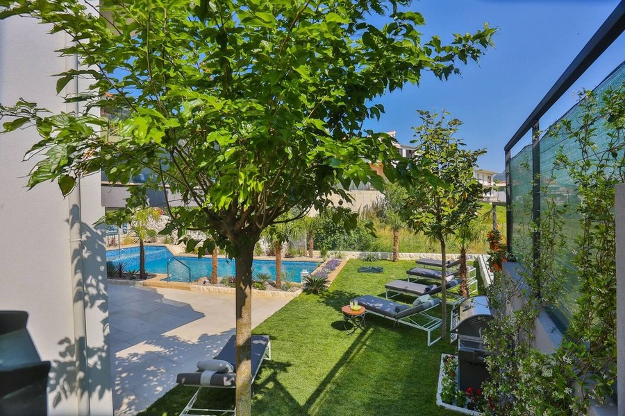Espace jardin ensoleillé avec transats au bord de la piscine