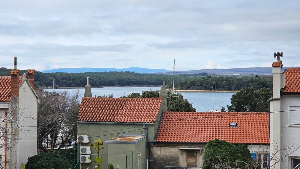Toits de tuiles avec vue par-dessus la baie sur la forêt