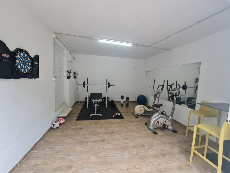 Salle de fitness avec appareils de sport et cible de fléchettes