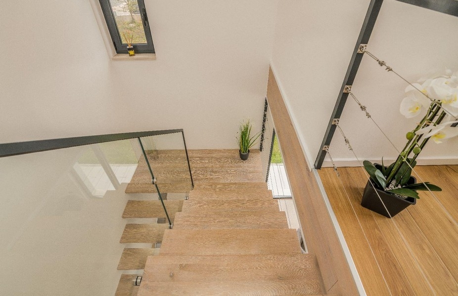 Escalier en bois avec garde-corps en verre et plantes