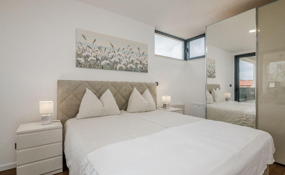 Chambre lumineuse avec lit double et armoire à miroir