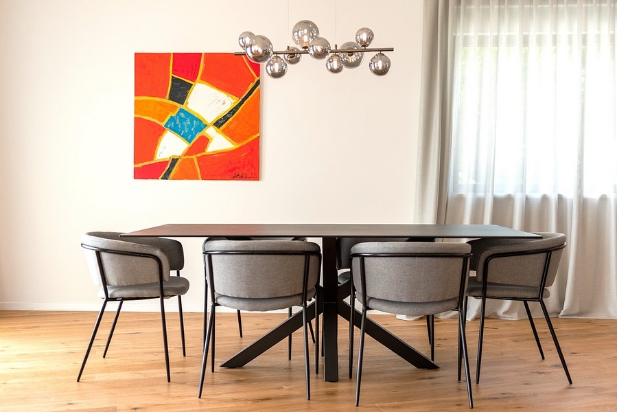 Coin repas avec luminaire design et grande œuvre d'art au mur