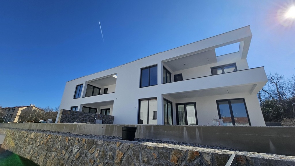 Maison blanche avec loggias au-dessus du mur en pierre naturelle