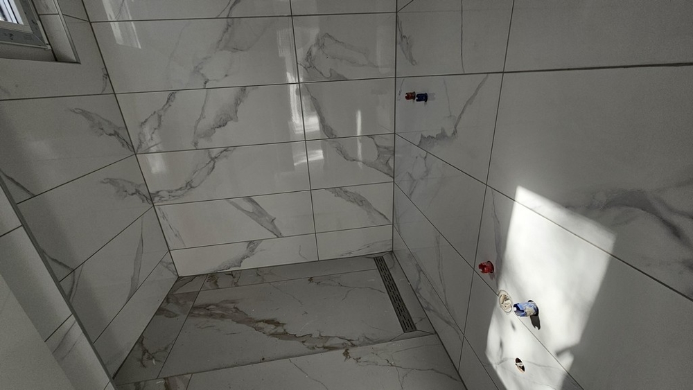 Salle de bains moderne carrelée avec douche