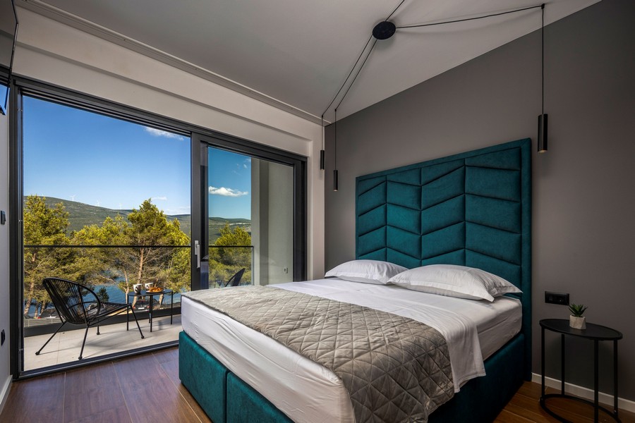 Chambre avec grand lit et fenêtre panoramique