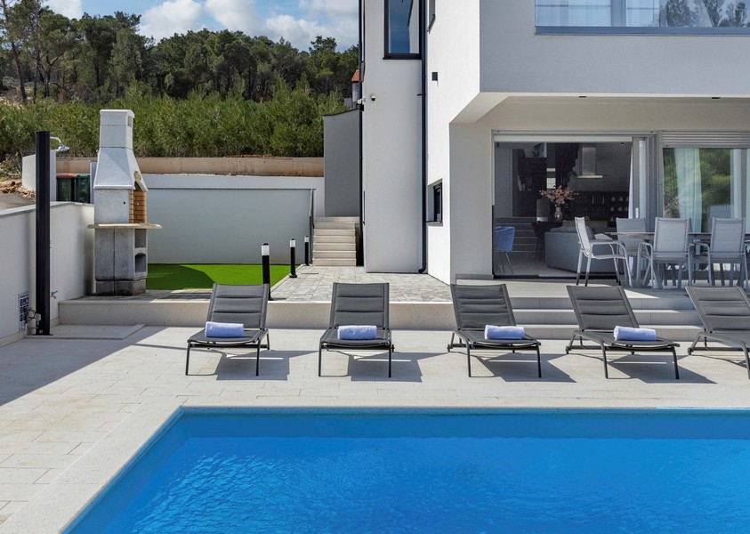 Piscine, solarium et vue sur le barbecue.