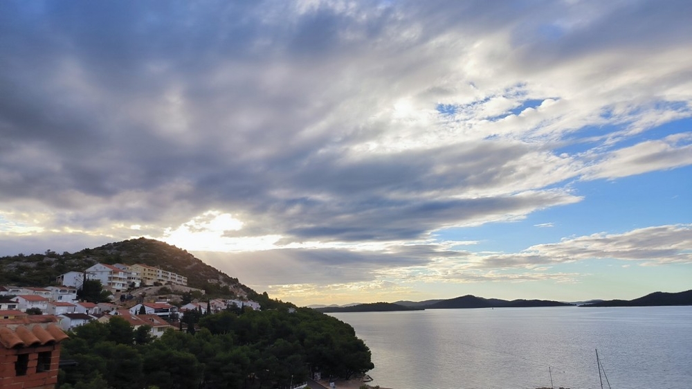 Ciel nuageux au-dessus de la baie avec le village à flanc de colline