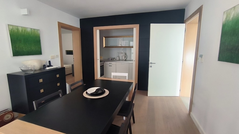 Salle à manger avec table foncée et liaison avec la cuisine