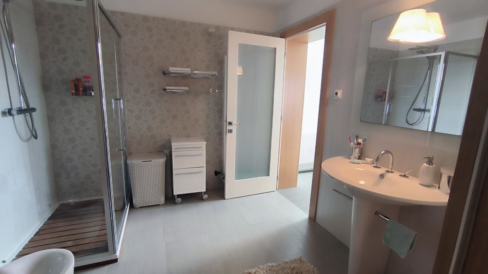 Salle de bains moderne avec grande douche et miroir