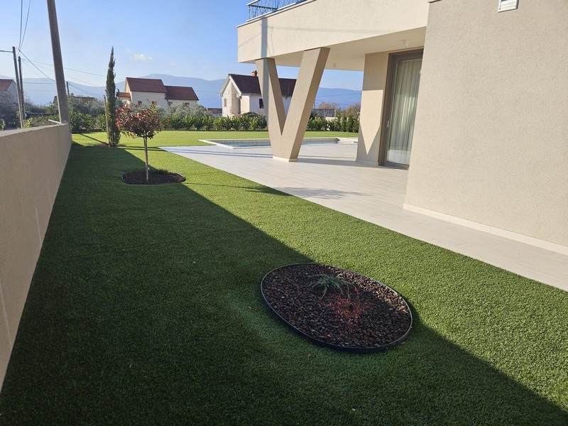Jardin moderne avec pelouse et terrasse d'une villa sur Krk
