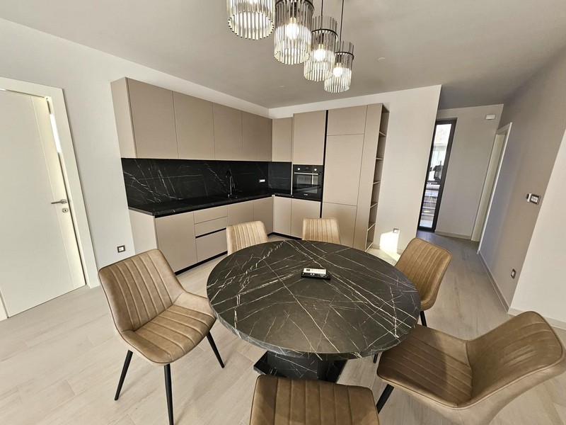 Cuisine moderne avec plans de travail noirs et table à manger ronde