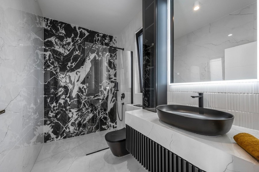 Salle de bains élégante avec carrelage en marbre et équipement noir