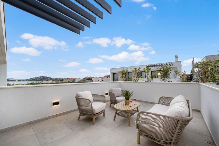 Terrasse moderne avec mobilier de salon et vue mer à Tribunj