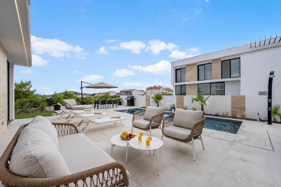 Espace extérieur avec piscine, bains de soleil et coin grill