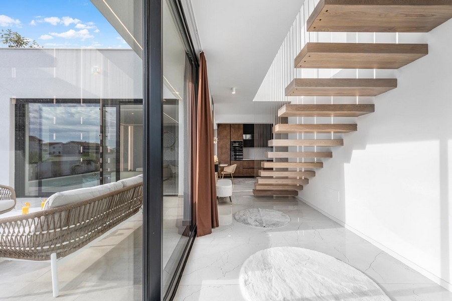 Galerie lumineuse avec escalier suspendu et grandes fenêtres