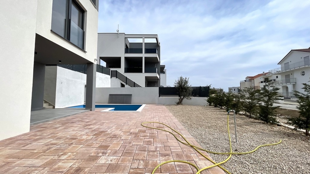 Terrasse moderne avec espace piscine et surface extérieure pavée
