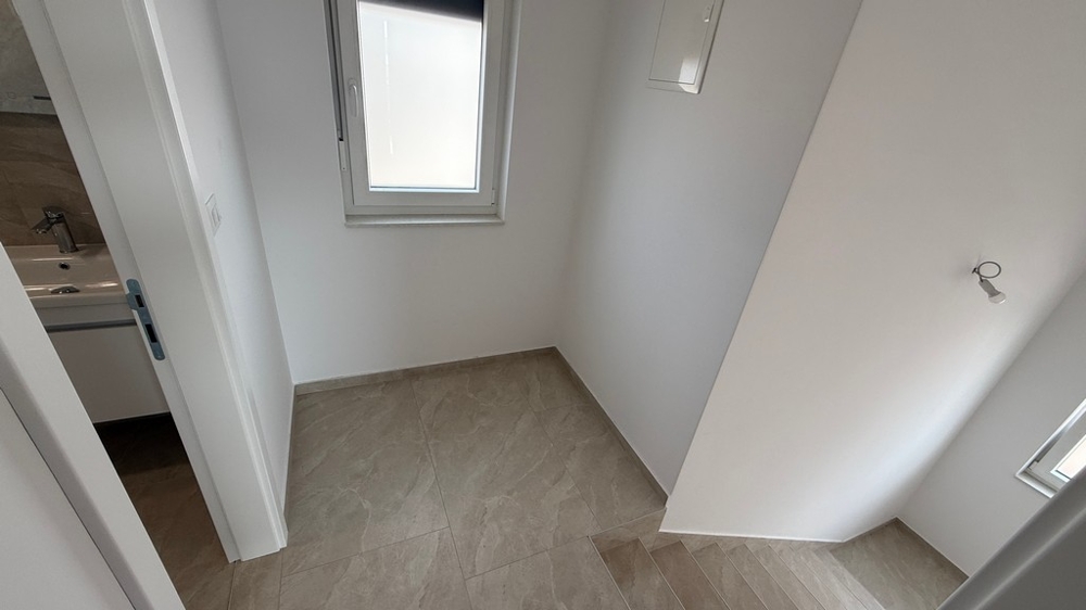 Cage d'escalier avec fenêtre et accès à la salle de bains