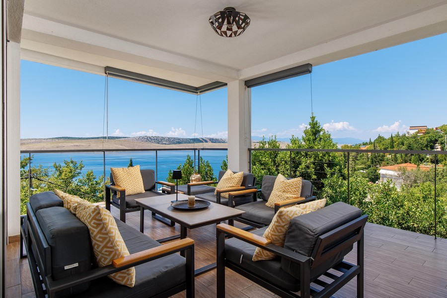 Terrasse couverte avec mobilier lounge et vue mer