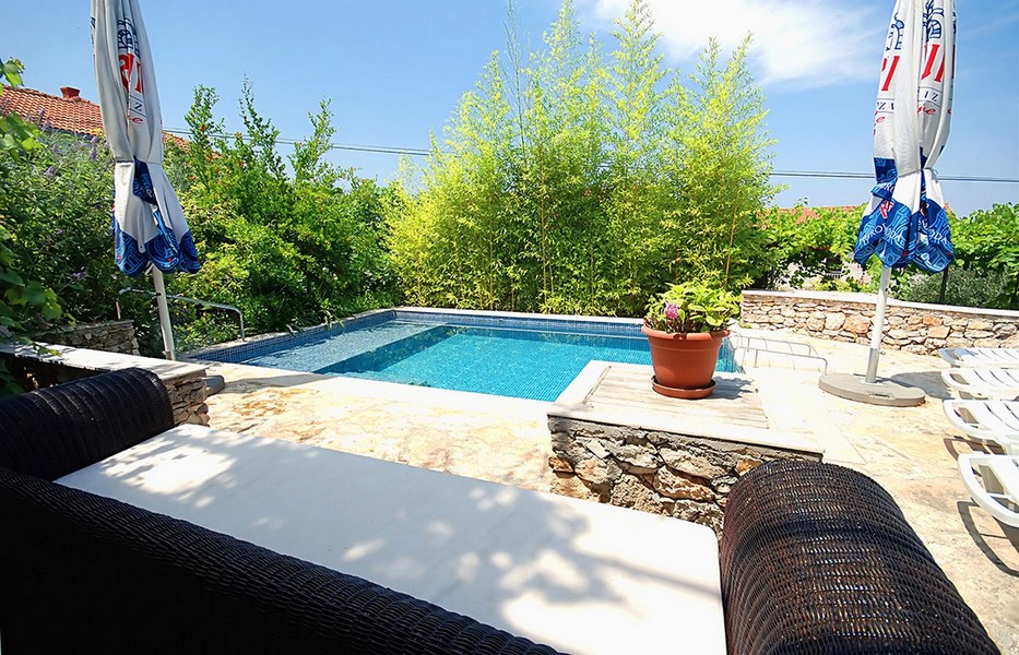 Espace piscine avec pierre naturelle et coin salon