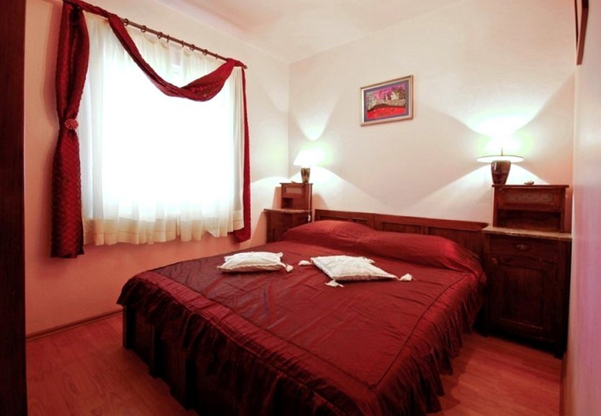 Chambre avec lit double et literie rouge