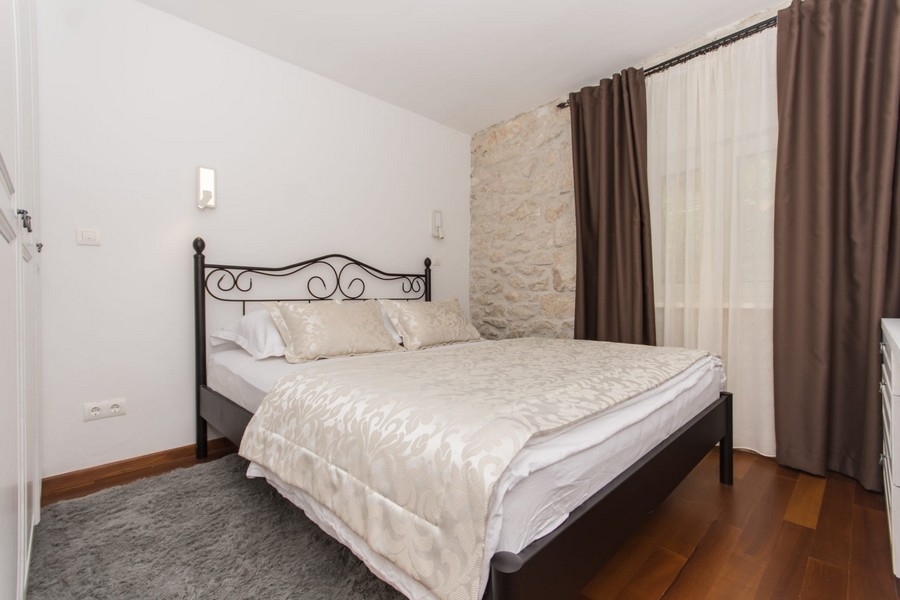 Chambre avec lit double et mur en pierre