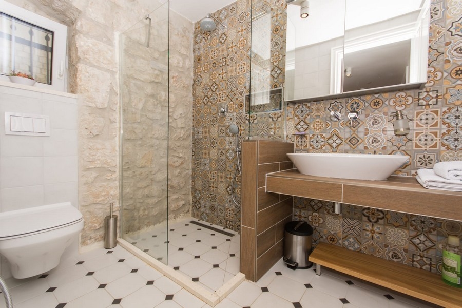 Salle de bains avec douche, bidet et carrelage mural à motifs