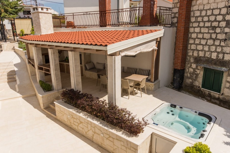 Terrasse avec jacuzzi et coin salon couvert