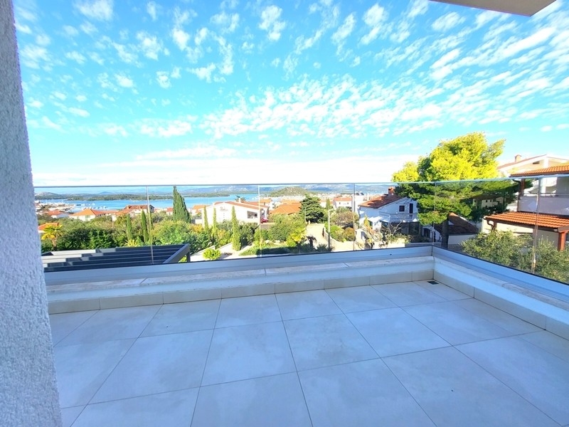 Terrasse vide avec garde-corps en verre et vue sur le village