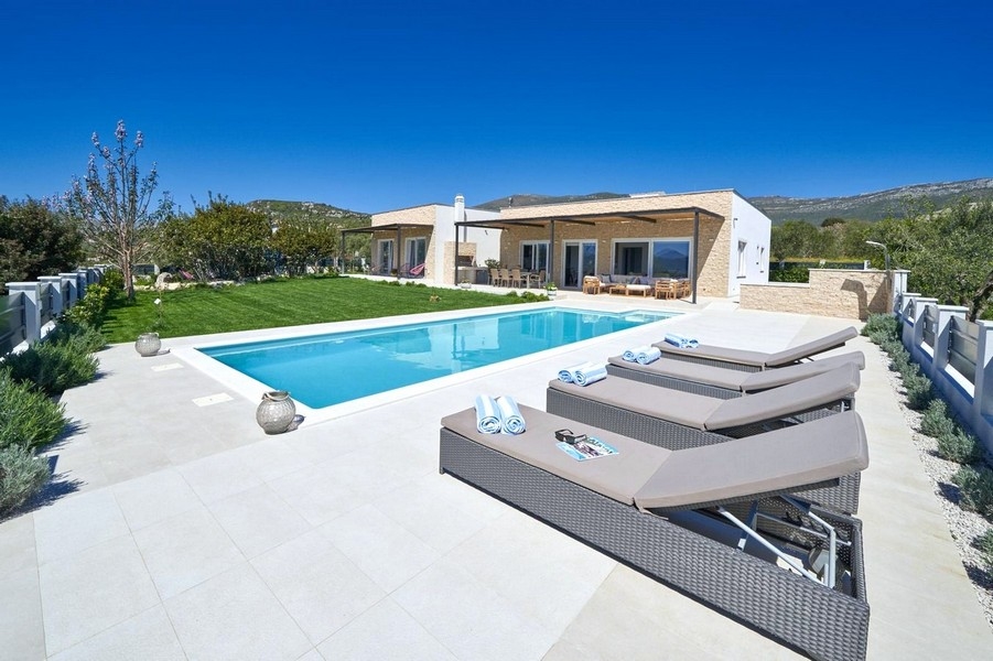 Villa moderne avec piscine et transats en journée
