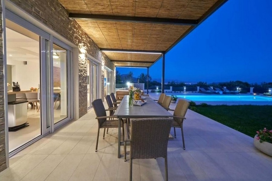 Coin repas sur la terrasse avec vue sur la piscine