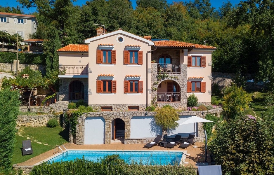 Villa avec soubassement en pierre naturelle et piscine dans le jardin en terrasses