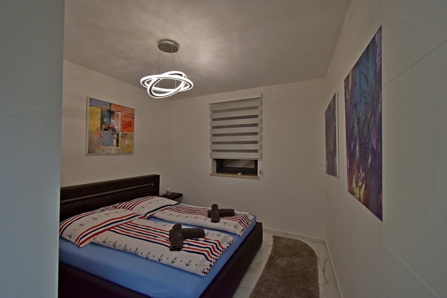 Chambre avec lit double et tableaux muraux