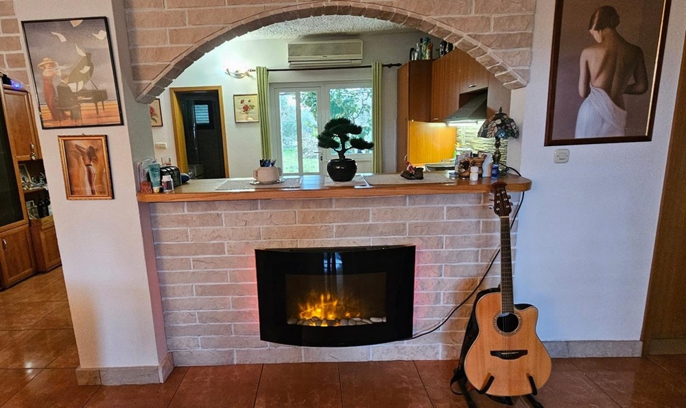 Coin cheminée avec guitare et tableaux muraux