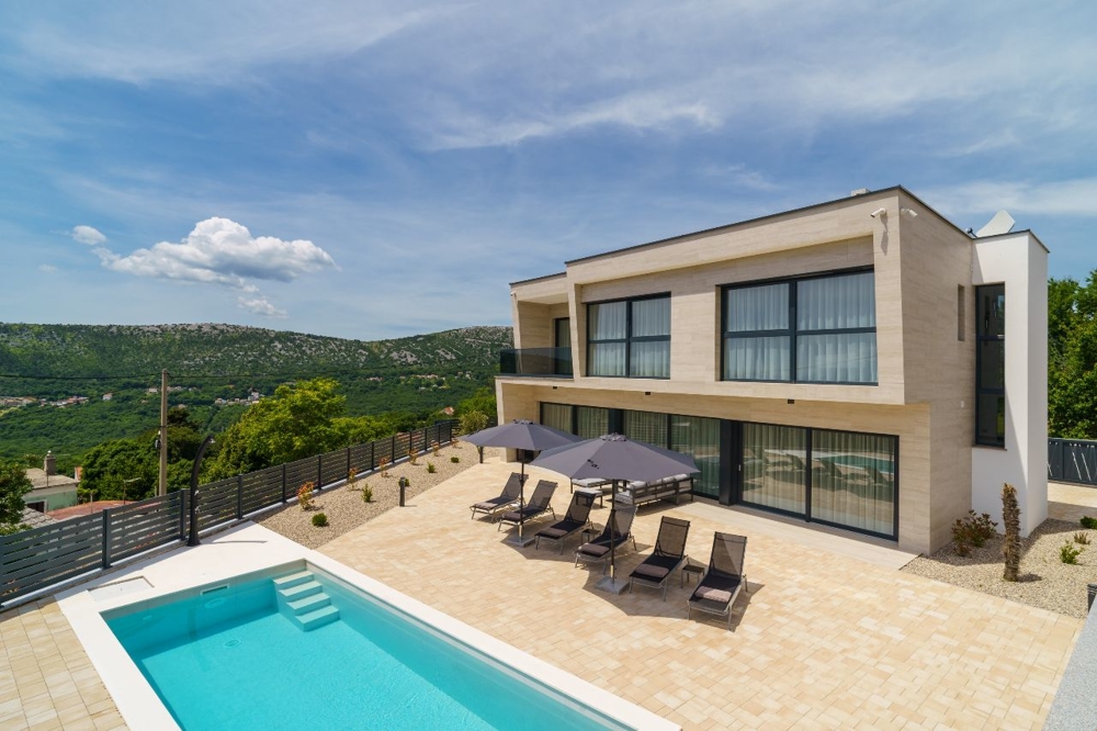 Vue extérieure de la villa avec solarium et piscine