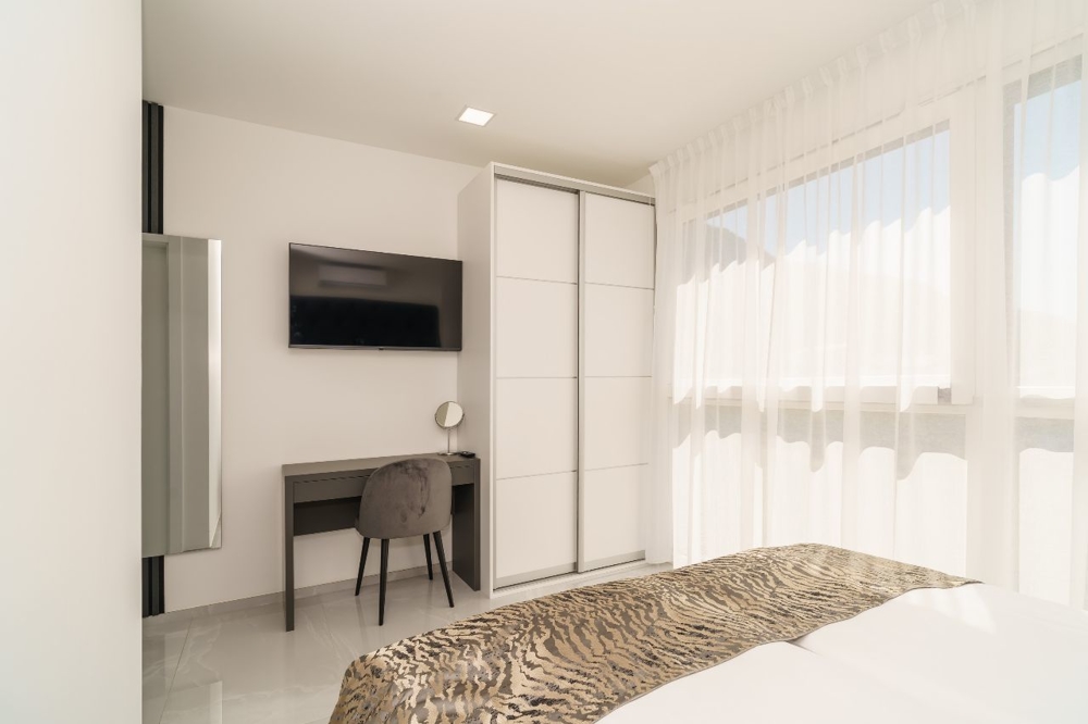 Chambre lumineuse avec bureau et TV