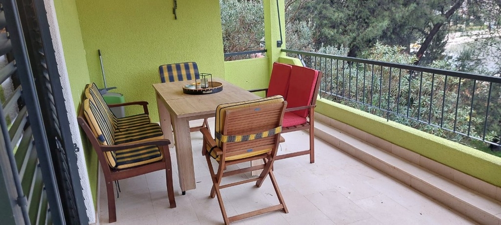 Loggia avec table en bois et chaises pliantes rouges