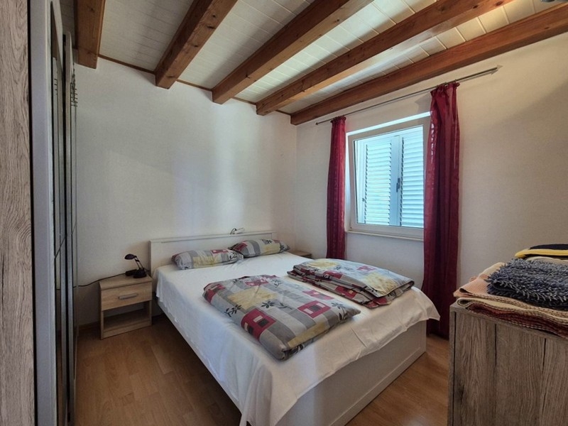 Chambre avec lit double et plafond à poutres