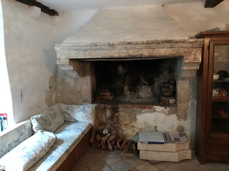 Ancienne cheminée en pierre avec banc