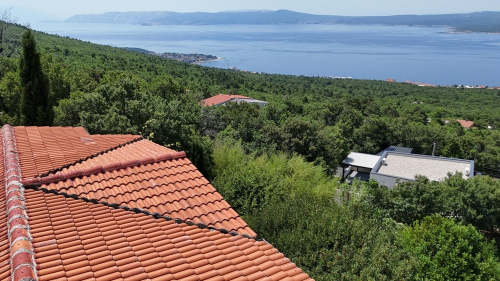 Toit de tuiles avec vue sur la forêt, la baie et les montagnes