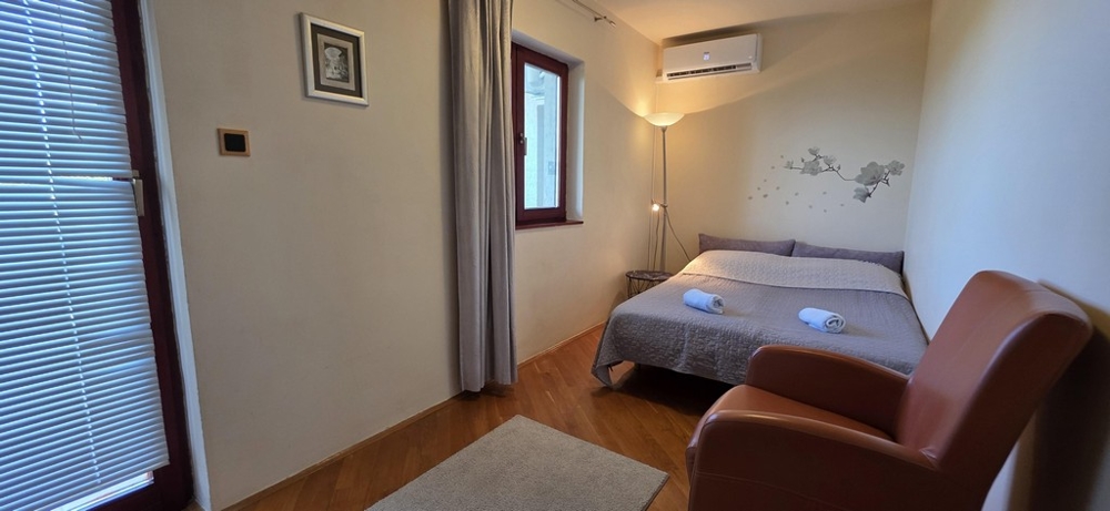 Petite chambre avec lit double et fauteuil