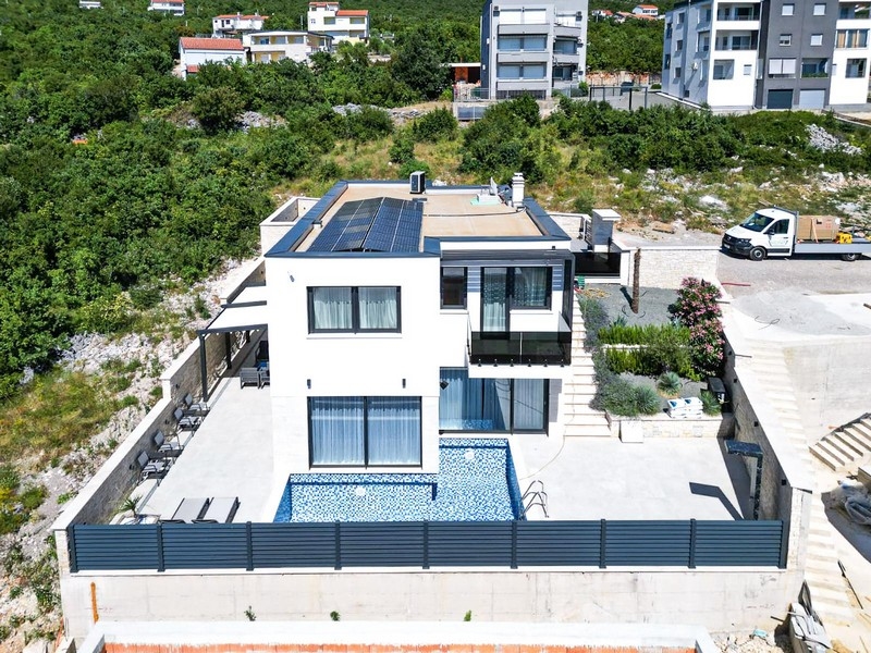 Vue aérienne de la villa avec panneaux solaires et piscine bleue