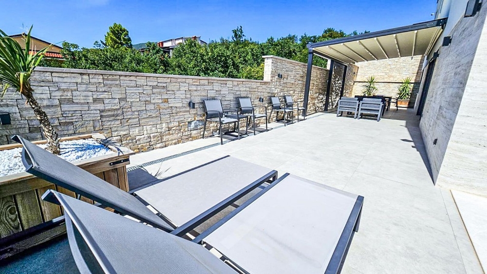 Spacieuse terrasse avec chaises longues